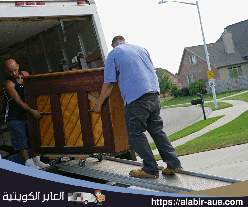 عامل نقل يقوم بتنظيم الأثاث داخل شاحنة النقل بطريقة مرتبة وآمنة في الجهراء