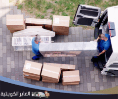 عمال نقل عفش يقومون بتحميل الأثاث في شاحنة داخل الكويت